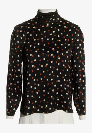 Blouse noire à manches longues avec col montant, décorée de petits cercles blancs et de carrés orange uniformément répartis.