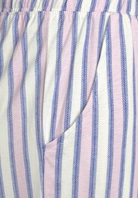 Gestreepte stof met roze en blauwe verticale lijnen; zachte textuur; elastische tailleband; bevat een zijvak.