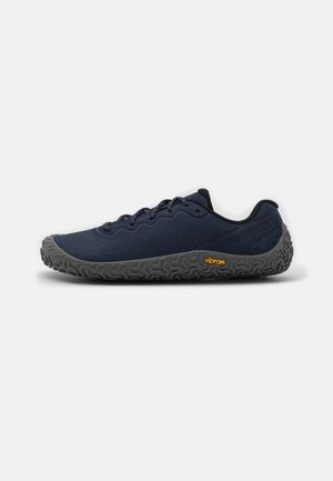 Granatowe buty trekkingowe z teksturowaną szaro-czarną podeszwą Vibram, z gładką cholewką, okrągłym noskiem i wytrzymałymi sznurowadłami. Logo na boku.