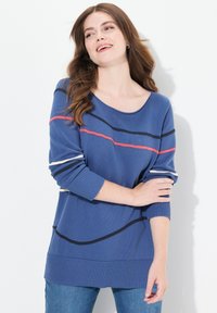 Blå tröja med bred halsringning, långa ärmar och randiga mönster i rött, vitt och marinblått. Ribbad nederkant och ärmslut, stickad textur.