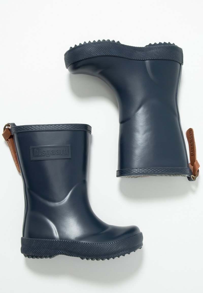 Botas de lluvia de goma azul marino con un acabado brillante, suelas texturizadas y detalles en cuero marrón que presentan un logo rectangular en la parte frontal.
