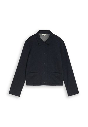 Zwart jasje met knopen, kraag, lange mouwen en twee voorzakken met steekopening, plat gelegd op een witte achtergrond.