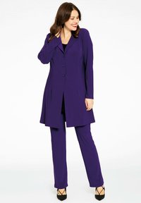 Puurpurne driekleurige outfit met een lange jas, strakke broek en een geweven textuur. De jas heeft een kraag en knoopsluiting, met een elegante uitstraling.