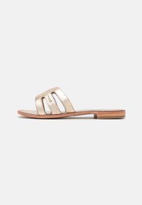 Infradito in metallo dorato con tre cinturini a taglio, soletta in legno piatta e tomaia in pelle liscia. Design semplice e struttura minimalista.