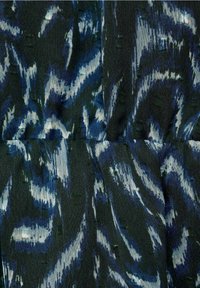 Tela multicolorida con una base verde oscura y patrones abstractos de olas en azul y blanco. Textura suave con hilos elevados sutiles.