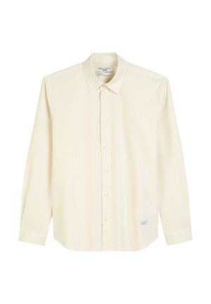 Light yellow long-sleeve button-up shirt with thin vertical stripes, a pointed collar, and a small logo patch on the lower side.