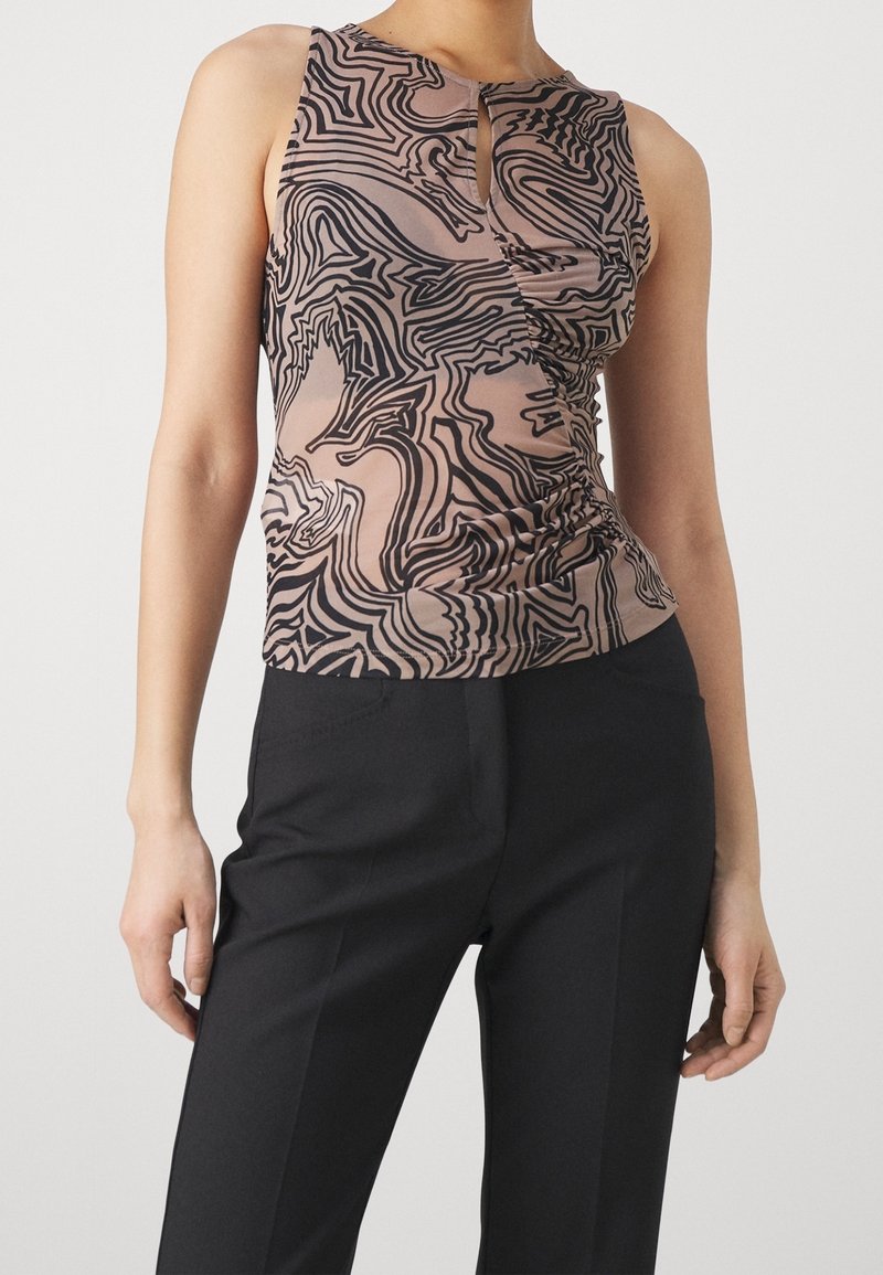 Top sans manches de couleur brun clair avec un motif de lignes abstraites noires, présentant un détail en goutte d'eau au niveau du décolleté et un froncé sur les côtés.