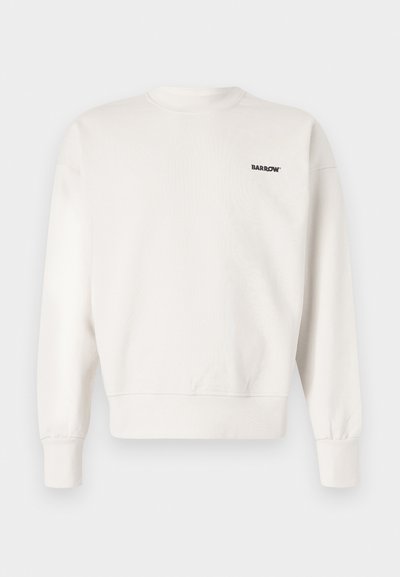 Sweatshirt col rond en beige clair, fabriqué en coton doux. Présente des poignets et un ourlet côtelés, avec un petit logo noir sur la poitrine gauche.