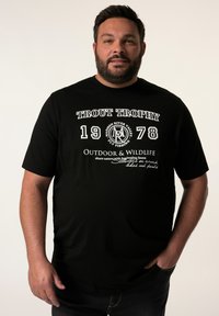 Černé bavlněné tričko s bílým nápisem "Trout Trophy 1978 Outdoor & Wildlife" a grafikou související s rybařením. Krátké rukávy.