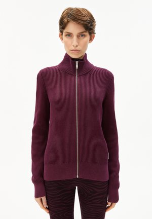 Sweater zippé en tricot côtelé violet avec col haut et manches longues, doté d'une fermeture éclair en argent et qui se porte près du corps.