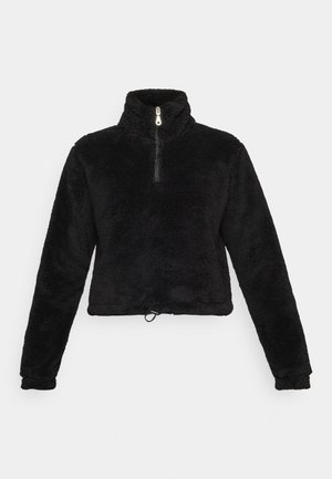 Pullover en polaire noir avec un col haut, demi-fermeture éclair et ourlet ajustable. Présente une surface douce et texturée ainsi que des manches longues.