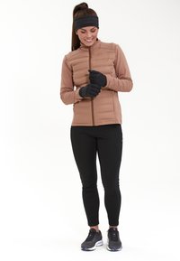 Doudoune marron clair avec une coupe ajustée, gants noirs, leggings noirs et chaussures de sport. Tissu lisse avec une texture élégante.