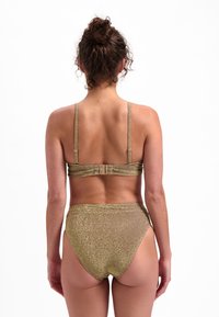 Set di bikini metallico dorato composto da un reggiseno con sottili spalline e chiusura posteriore, abbinato a slip bikini a vita alta. Tessuto sparkly in tutto.