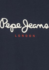 Camiseta de algodón azul marino con gran texto en cursiva blanca "Pepe Jeans" y texto más pequeño en rojo "LONDON" debajo. Textura suave.