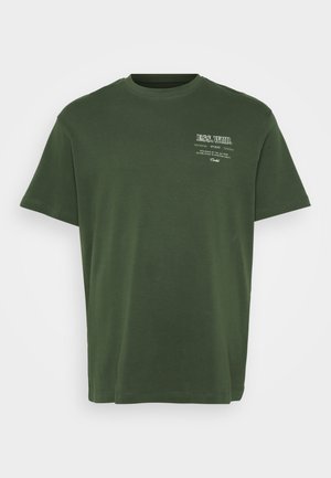 T-shirt en coton vert avec un col rond, des manches courtes et un texte imprimé en blanc sur le côté supérieur gauche. Texture lisse, coupe décontractée.