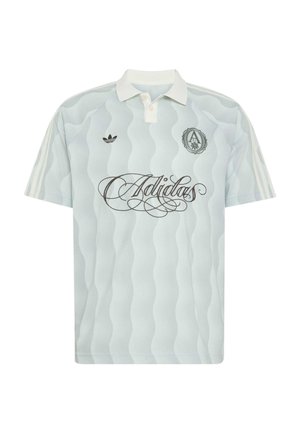 Světle modré polo tričko Adidas s bílým vlnkovým vzorem, bílým límečkem, třemi bílými pruhy na rukávech, černým logem Adidas a psaným textem na přední straně.