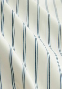 Țesătură de bumbac cu dungi verticale albastre pe un fundal alb, având o textură fină și o cădere ușoară.