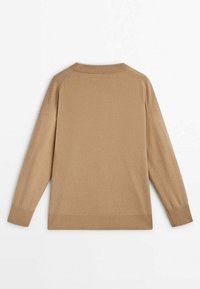 Beige stickad tröja med rund hals, raglanärmar, ribbade muddar och en mjuk känsla. Bakvy med minimal detaljer.