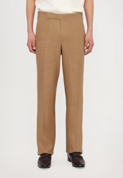 Beige Leinenhosen mit geradem Bein, flachem Vorderteil und Seitentaschen. Mit einer glatten Textur und einem dezenten Glanz versehen.