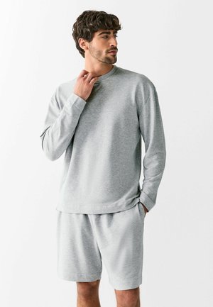 Gray sweatshirt with long sleeves and a round neckline, paired with gray shorts. Made of soft, textured fabric, featuring a relaxed fit.