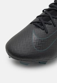 Crne nogometne kopačke s teksturiranom površinom, s istaknutim Nike logoom u tamnozelenoj boji i elegantnim oblikom dizajniranim za performanse.