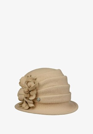 Beige Glockenhut mit geschichteten Stofflagen und dekorativer Schleife, die an der Seite mit kleinen goldenen Perlen verziert ist.