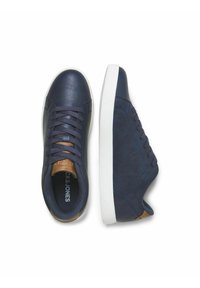 Navy blue sneakers with a textured leather upper, white rubber sole, and brown accent on the heel. Features classic lace-up design.