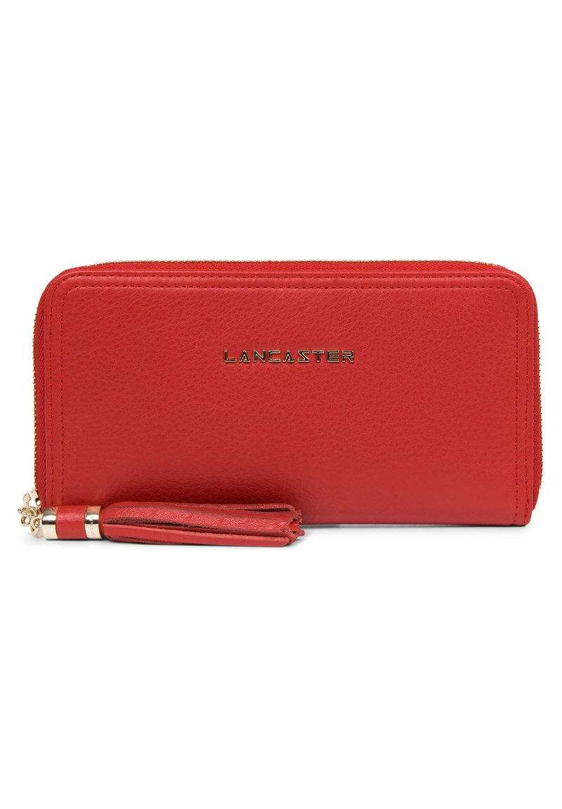 Portefeuille en cuir rouge avec fermeture éclair, logo en relief "LANCASTER" et une frange décorative. Texture lisse avec bords cousus.