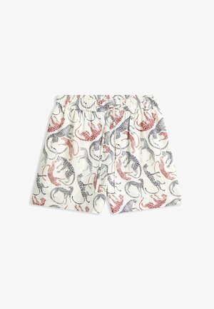 Shorts à taille élastique blanche avec des motifs léopard rouges et noirs dispersés sur le tissu.