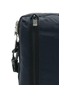 Navy blue padded bag with a black zipper, featuring a metal logo tag and a clip hardware on the side. Textured surface.