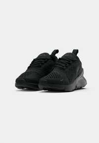 Schwarze Sportchuhe mit einem Obermaterial aus Mesh, strukturierten Akzenten, dünnen Schnürsenkeln, gepolstertem Schaft und einer gepolsterten Sohle. Minimalistisches Design ohne Logos.