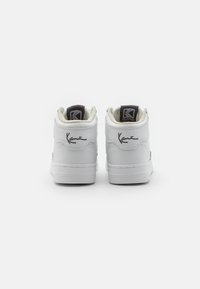 Hvite high-top sneakers med teksturert lær, polstrede krager og svarte logodetaljer. Signaturdetalj sydd på baksiden.