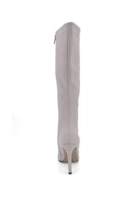 Knöchelhoher, hellbeiger Lederstiefel mit einem schmalen Absatz und einem seitlichen Reißverschluss. Glatte Textur mit minimalen Nähten.
