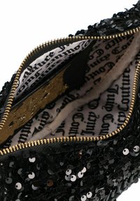 Borsa a mano nera con paillettes e zip dorata; l'interno presenta una fodera in tessuto con un motivo a logo ripetuto in stampa scura su uno sfondo chiaro.