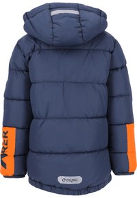 Marineblå pufjakke med hætte, med orange detaljer på ærmerne og en reflekterende stribe på ryggen. Lavet af quiltet materiale.