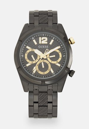 Sort metalurur med guld accenter, der har en tekstureret urskive, chronograf underdials og et link armbånd design.