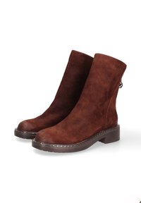 Bruine suède enkellaarzen met een ronde neus, een stevige hak en decoratieve metalen studs langs de zool. Achterlus voor makkelijk aan- en uittrekken.