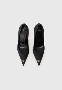 Black pointed-toe heels in satin material, featuring a gold accent at the front, smooth texture, and a low cut on the sides.