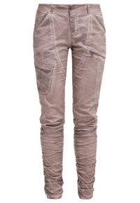 Jasnobrązowe, zwężane spodnie cargo z kieszeniami na zamek i naszywkami; wykonane z miękkiego, teksturowanego materiału; z ozdobnym przeszyciem i marszczonymi mankietami.