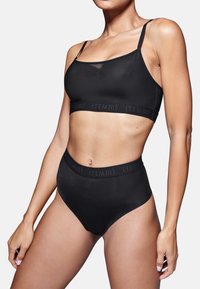 Set di bralette nera e mutandine a vita alta realizzato in tessuto morbido. Presenta spalline sottili e una fascia con dettagli in rilievo del logo del marchio.