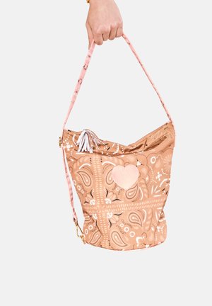 La borsa a secchiello a motivo marrone chiaro presenta una tracolla rosa, un dettaglio a forma di cuore e delle frange. Il design include motivi floreali e paisley.