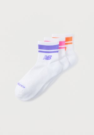 Trois paires de chaussettes blanches pour chevilles avec des bords côtelés, chacune présentant deux rayures et un logo New Balance en violet, rose et orange.