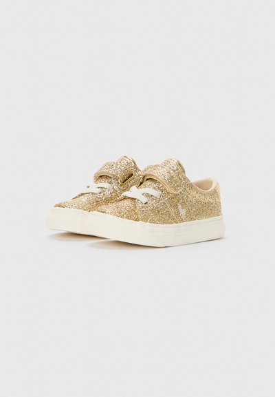 Sapatilhas douradas cintilantes com atacadores brancos e sola off-white; bico arredondado, superfície texturizada e colarinho suave e acolchoado.