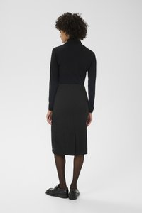 Must pikkade varrukatega top, mis on kombineeritud halli mustriga pliiatsseelikuga, millel on tagumine lõhik. Komplekti kuuluvad mustad kingad.