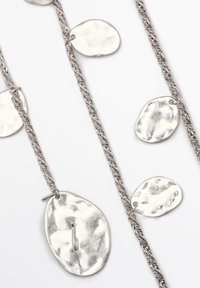 Silver pendant necklace with a braided chain. Features textured, irregularly shaped metallic discs of varying sizes.