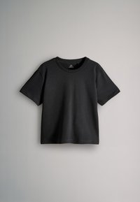 Must lühikeste varrukatega ümara kaelusega T-särk, kujutatud laiali laotatult heledal hallil taustal, krae sees silt "THE SET".