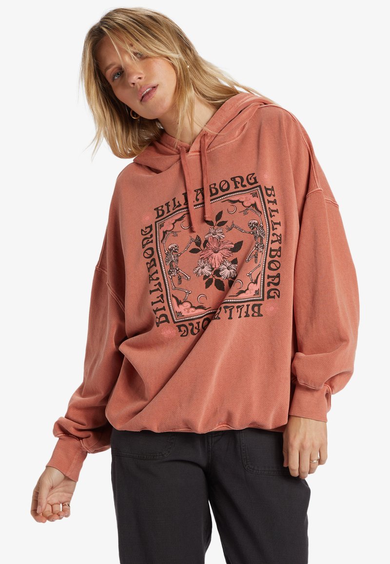 Felpa color rosa con vestibilità rilassata. Presenta un design grafico di fiori e scheletri incorniciati da testo. Maniche lunghe con dettagli ai polsini.