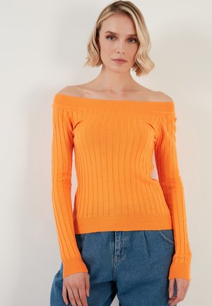 Orange, ribbed knit off-shoulder sweater with long sleeves and fitted hem. Paired with loose blue denim jeans. Simple design, vibrant color.