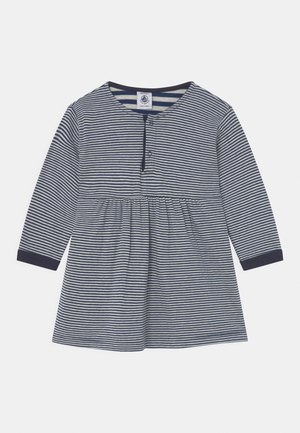 Dlouhé šaty s modro-bílými pruhy, zaobleným výstřihem, knoflíkovou légou a nařaseným pasem. Měkká bavlněná tkanina.