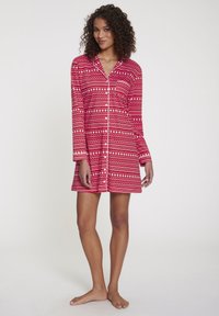 Crvena noćna haljina s dugim rukavima, ukrašena geometrijskim uzorcima u bijeloj i ružičastoj boji. Napravljena od mekane, lagane tkanine, do koljena.